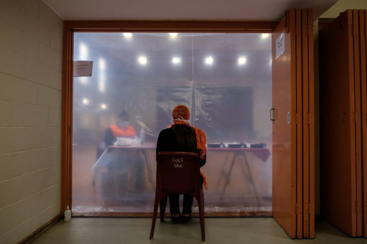 A patient sits in consultation with healthcare workers before being tested for COVID-19 coronavirus at the Schotsche Kloof Civic Centre in Cape Town