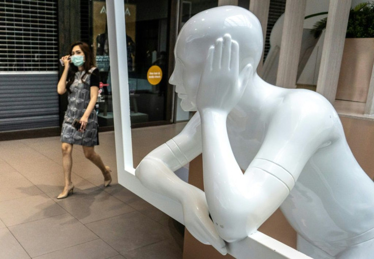 A woman wearing a face mask enters a shopping mallin Bangkok