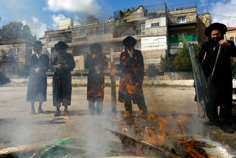 Jewish men burn food with leavening agents ahead of the start of Passover, in the the ultra-Orthodox Mea Shearim neighbourhood of Jerusalem