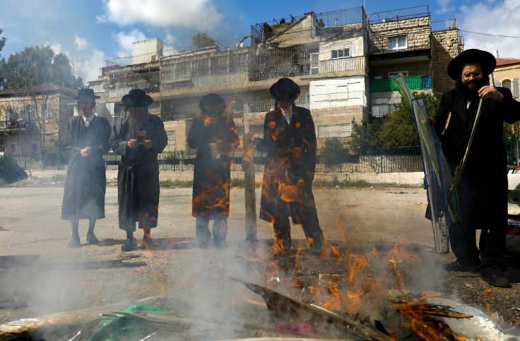 Jewish men burn food with leavening agents ahead of the start of Passover, in the the ultra-Orthodox Mea Shearim neighbourhood of Jerusalem