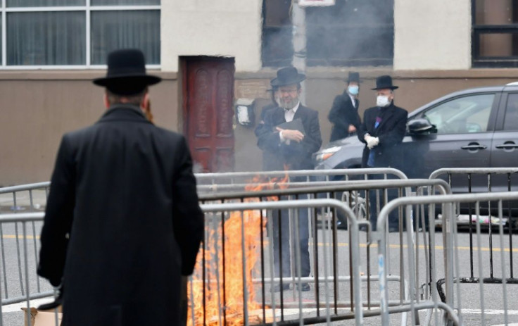 Members of the Orthodox Jewish community gather to burn leavened products as the Passover holiday starts Wednesday evening and runs to April 16