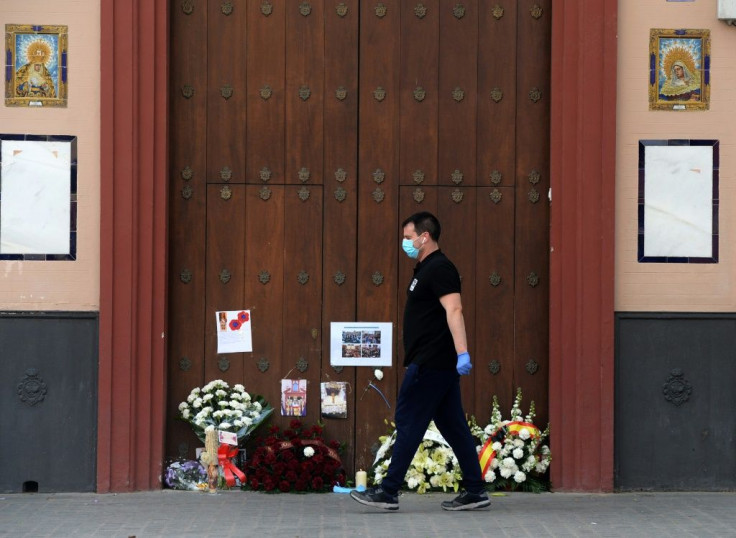 A man walks past the Pieta Chapel in Seville, adorned with flowers and candles left by the faithful in the lead up to Easter Sunday