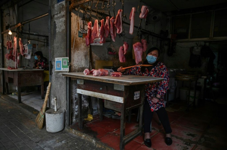 A woman tends her meat stall in Wuhan, where the coronavirus started. Life is slowly returning to normal in the city, but fears remain