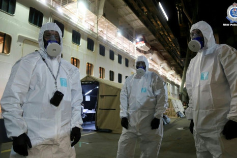 Police officers in protective gear prepare to board the coronavirus-stricken Ruby Princess cruise ship and seize its black box at Port Kembla, Australia