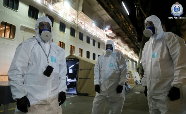 Police officers in protective gear prepare to board the coronavirus-stricken Ruby Princess cruise ship and seize its black box at Port Kembla, Australia