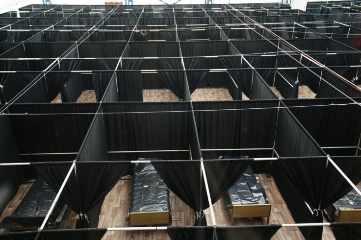Rows of beds separated by black fabric are set up as a temporary field hospital for COVID-19 patients at the USTA Billie Jean King tennis center in New York