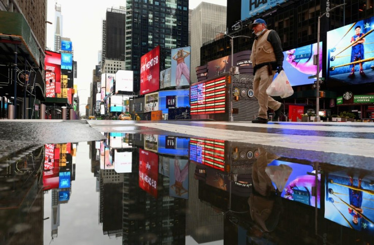 A man crosses the street at a nearly empty Times Square on April 09, 2020 in New York City