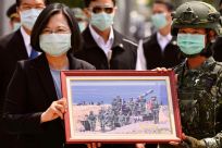 Taiwan President Tsai Ing-wen receives a framed photograph from a masked soldier during the COVID-19 coronavirus pandemic during a visit to a military base in Tainan on April 9, 2020