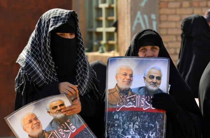 Iraqi women hold portraits of Iran's late top general Qasem Soleimani and Iraqi paramilitary commander Abu Mahdi al-Muhandis, killed in a US drone strike near Baghdad in January 2020