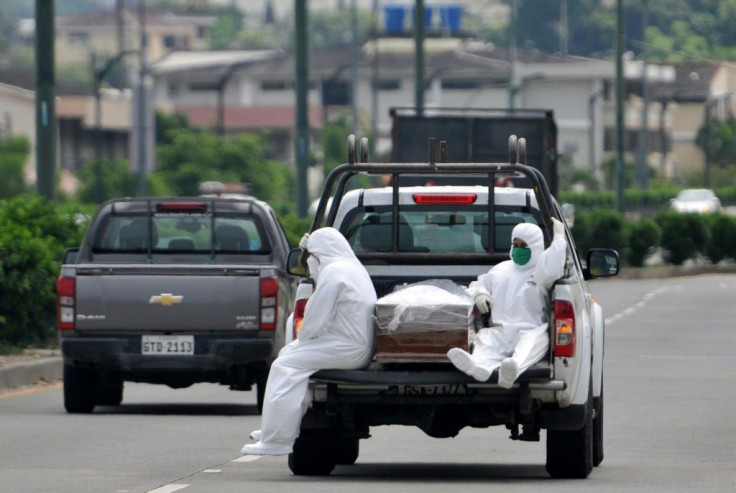 People wearing protective suits accompany a coffin on a truck near Los Ceibos hospital in Guayaquil, Ecuador on April 8, 2020