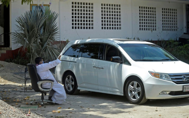 Priest Marco Antonio Galeana hears confession from a penitent in a car in Acapulco, Mexico