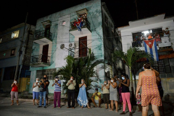 Neighbours applaud doctors and nurses who are battling the virus in Havana on March 30, 2020. Cuba is having trouble securing the medical supplies it needs to fight the pandemic