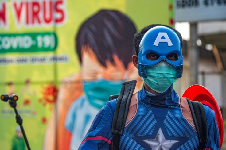 An Indonesian police officer wearing a superhero costume on the street disinfects motorists' vehicles in Pasuruan, East Java