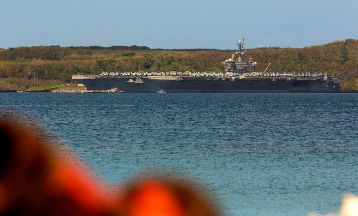The aircraft carrier USS Theodore Roosevelt docked in Guam as authorities try to counter a coronavirus outbreak that has infected at least 585 of the ship's 4,800 crew and left one saiilor dead on Monday