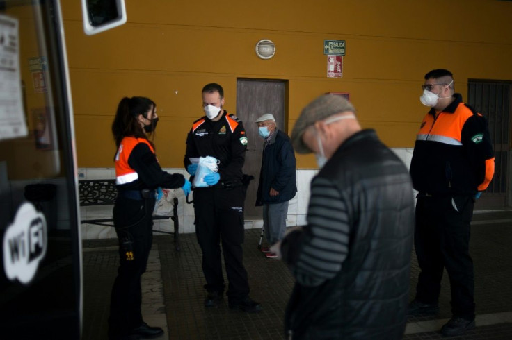 Spanish Civil Protection members distribute face masks in Ronda as some companies were set to resume operations after a two-week halt of all non-essential activity amid a national lockdown to stop the spread of the novel coronavirus.