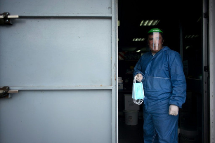 A worker holds face masks distributed by Spanish volunteers in Ronda as some companies were set to resume operations following a two-week halt of all non-essential activity amid a national lockdown to stop the COVID-19 spread.