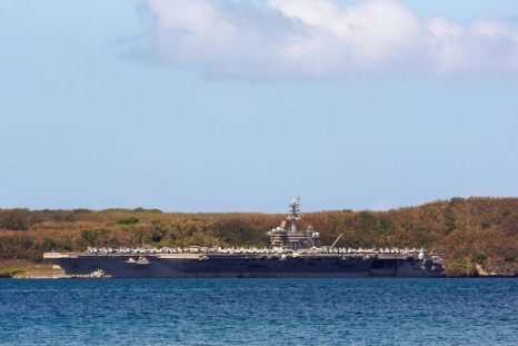 The aircraft carrier USS Theodore Roosevelt docked in Guam as authorities try to counter a coronavirus outbreak that has infected at least 585 of the ship's 4,800 crew and left one saiilor dead