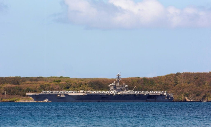 The aircraft carrier USS Theodore Roosevelt docked in Guam as authorities try to counter a coronavirus outbreak that has infected at least 585 of the ship's 4,800 crew and left one saiilor dead