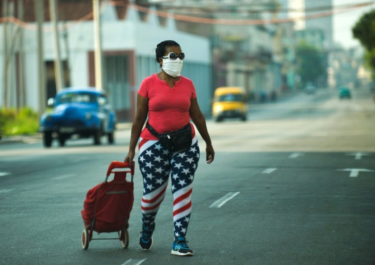 A woman wearing leggings depicting the US flag, walks along a street in Havana, on April 13, 2020