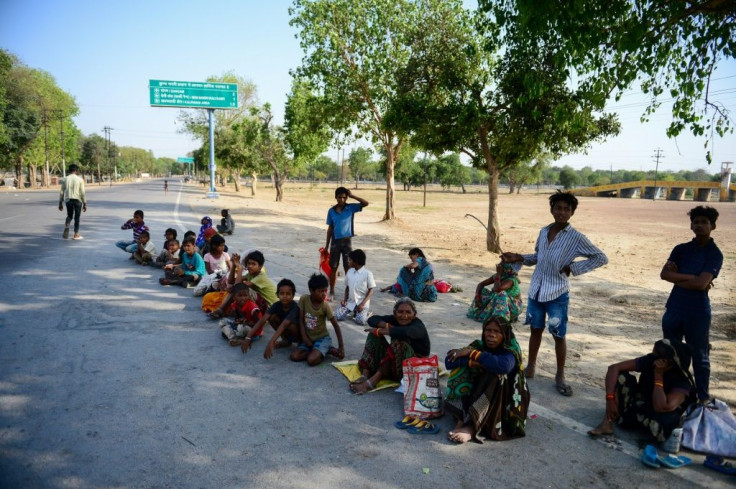 Homeless people wait along a road in Allahabad to receive free food during the nationwide lockdown