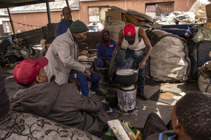 A group of reclaimers -- people who pick up and sell recyclable rubbish -- cook food at the Bekezela slum in Johannesburg. Most people here are depending on food donations to survive during the country's lockdown