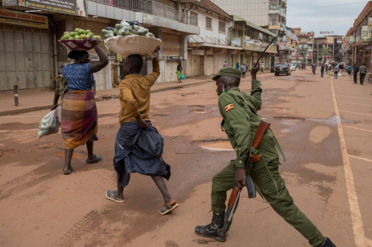 A policeman in the Ugandan capital Kampala beats an orange hawker for defying stay-at-home instructions