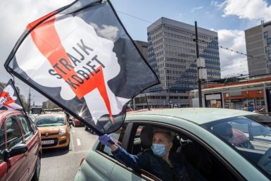 A women waves a flag from her car as part of a Warsaw protest against further tightening Poland's already restrictive abortion laws