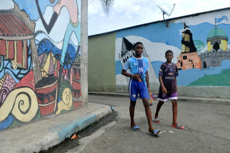 Children walk along a street of the Nigeria neighborhood in Guayaquil, Ecuador, a port city where hundreds of people have died of COVID-19