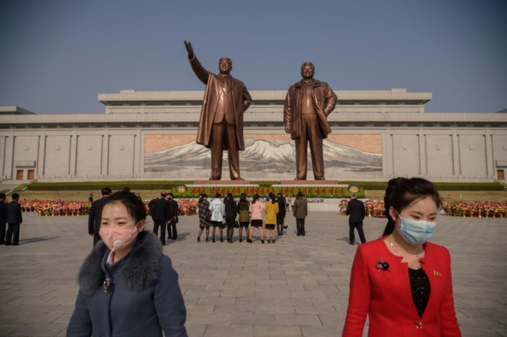 Pyongyang residents pay their respects at the giant bronze statues of Kim Il Sung and his son and successor Kim Jong Il
