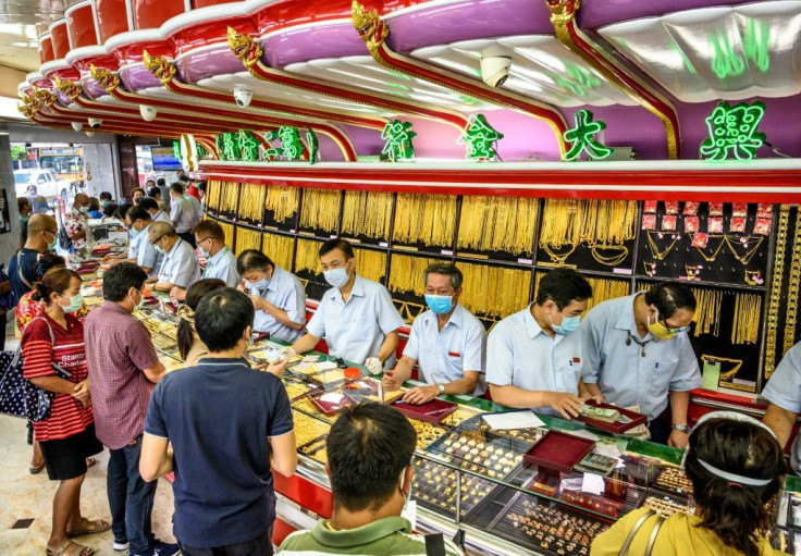 Customers in facemasks selling gold at a shop in Bangkok's Chinatown