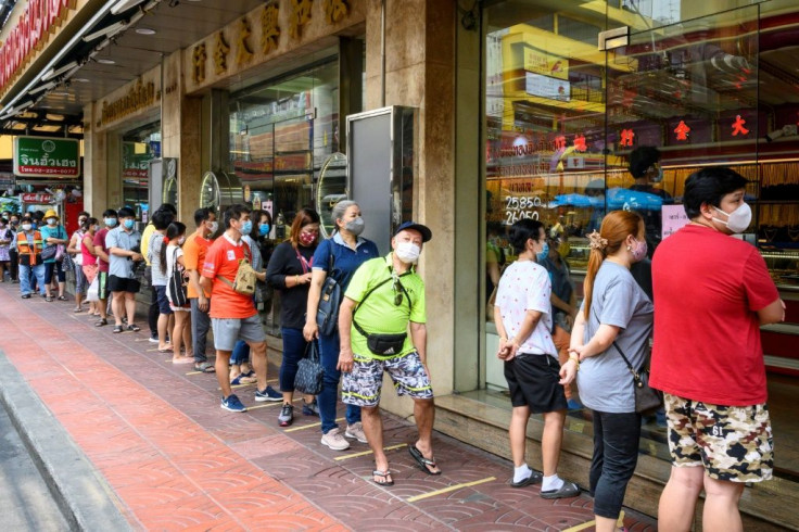 Customers line up outside a gold shop in Bangkok, ready to sell their jewellery as the price of the precious metal soars