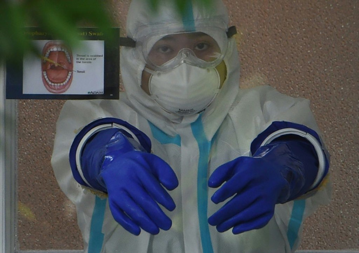 A medical worker prepares to conduct a test for COVID-19 in Manila