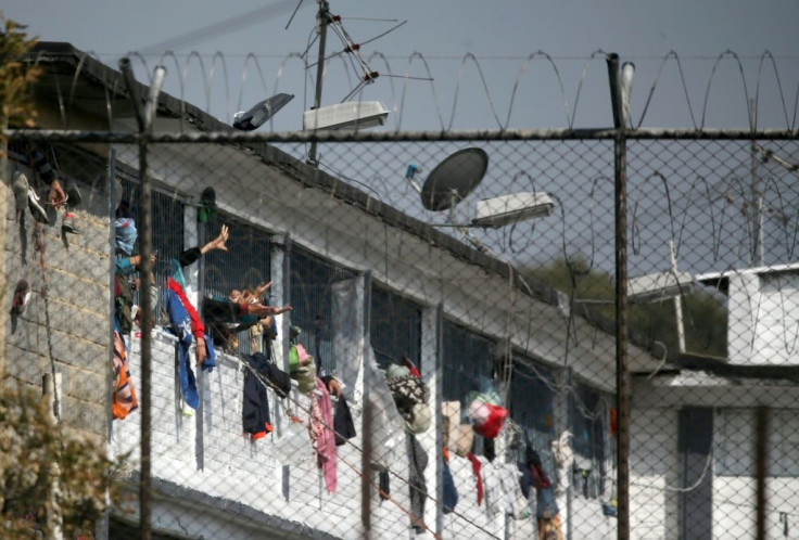 Inmates extend their hands at the Modelo prison in Bogota after a riot on March 22 left 23 prisoners dead and 90 wounded