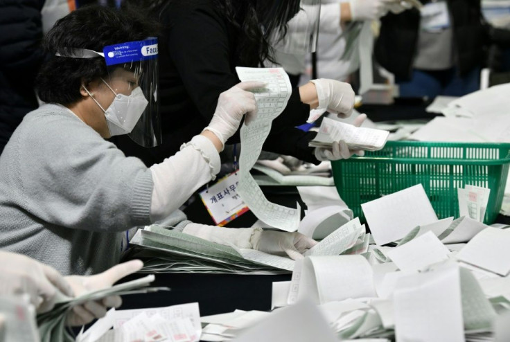 South Korean election officials sort voting papers for ballot counting at a gymnasium in Seoul on April 15