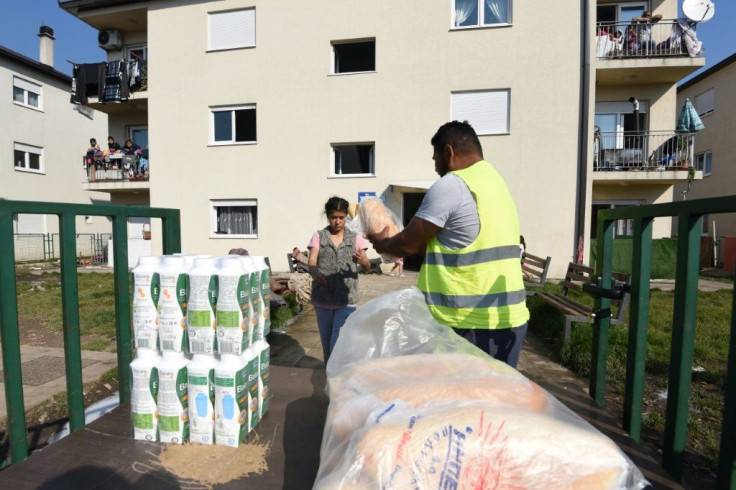 Montenegrin Red Cross workers and volunteers deliver bread and milk to the Roma community on the outskirts of Podgorica