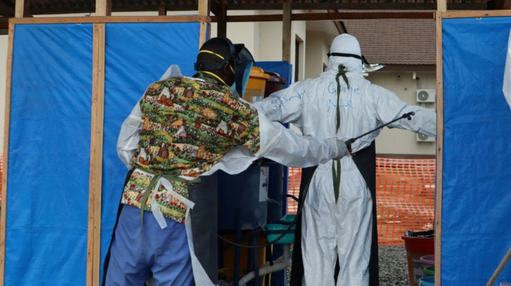 Doctors coming out of the red zone at the Intensive Care Unit (ICU) are carefully disinfected by hygienists at the 14 Military Hospital in Monrovia, Liberia