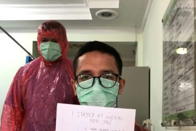 Doctor Muhammad Farras Hadyan, wearing a raincoat because of a shortage of proper protection gear, poses for a selfie during a break from treating patients with coronavirus, in Jakarta