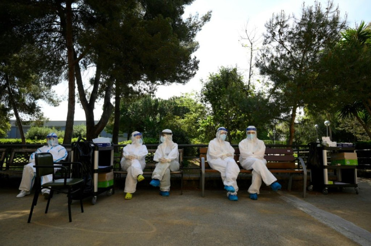 Healthcare workers wearing protective suits wait during a COVID-19 testing campaign at a care home for the elderly in Barcelona