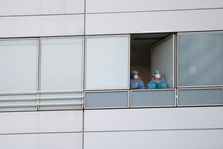 Healthcare employees of the Georges Pompidou European hospital respond to taxi drivers who gathered in front of the hospital to applaud them in Paris