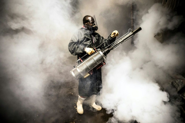 A member of a privately-funded NGO  fumigates and disinfects the streets and the stalls at Parklands City Park Market in Nairobi, Kenya