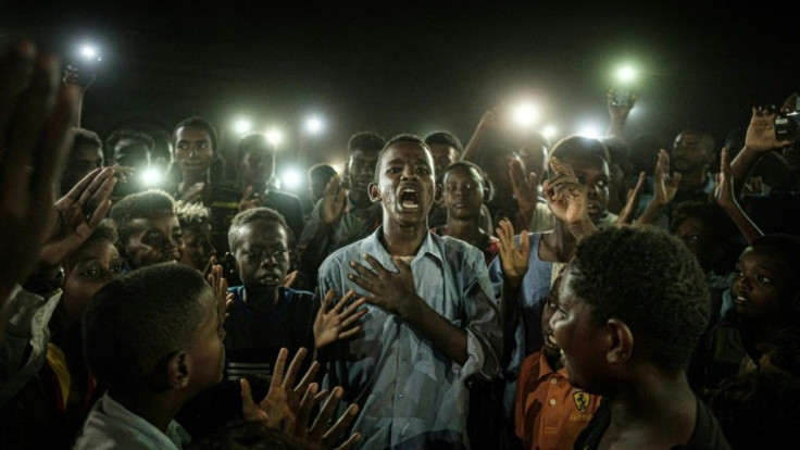 Agence France-Presse photographer Yasuyoshi Chiba has won the prestigious World Press Photo of the Year Award with a picture of a mobile-lit Sudanese demonstrator reciting protest poetry in which judges saw a symbol of hope.