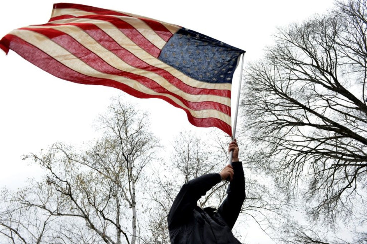 A protester in Concord, New Hampshire waves a flag during a rally urging a quick end to virus-related confinement rules