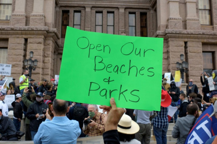 A protester holds up a sign during the "Reopen America" rally in Austin, Texas