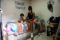 A Medellin sex worker and her young daughter sort through a food package donation