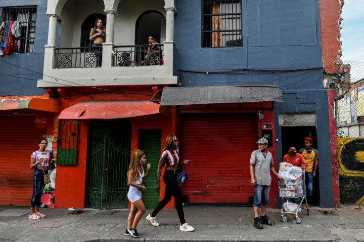 People walk outside a low-cost hotel where prostitutes live and work in Medellin, Colombia