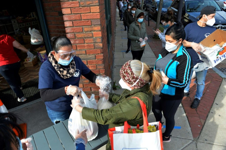 Food and packages of donated goods are distributed to people at a food bank in Chelsea, Massachusetts