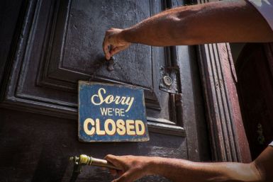 An employee of Havana's El Cafe coffee shop puts up a sign that has become a familiar sight during the coronavirus pandemic