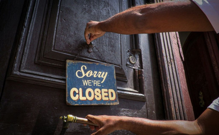 An employee of Havana's El Cafe coffee shop puts up a sign that has become a familiar sight during the coronavirus pandemic