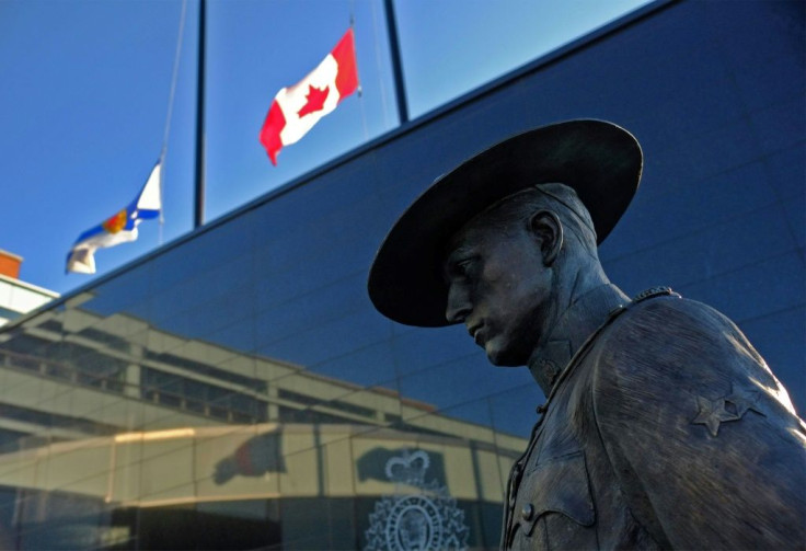 Flags of Nova Scotia and Canada fly at half-staff outside the Nova Scotia Royal Canadian Mounted Police (RCMP) headquarters in Dartmouth, Nova Scotia, after at least 10 people including an RCMP officer were killed in a shooting rampage