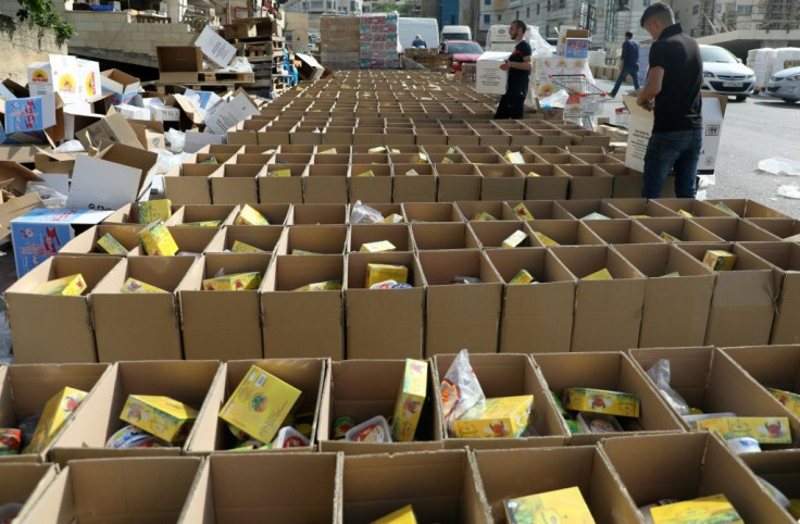 Volunteers fill up carton boxes with food items to be distributed to needy Palestinian families in the occupied West Bank city of Nablus ahead of Ramadan, a period also characterised by charity